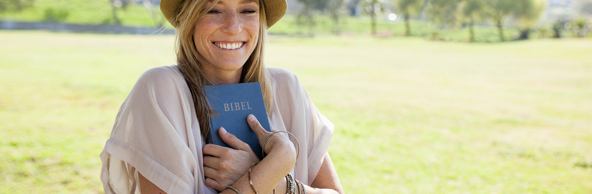 Lächelnde Frau hält Bibel in den Händen